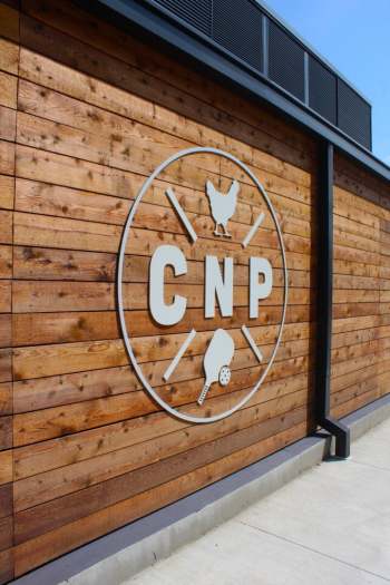Natural wood panel wall at Chicken N Pickle