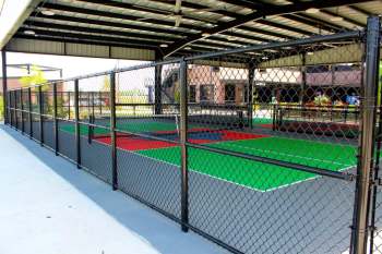 Chain-link fencing enclosing colorful pickleball courts