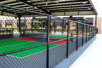 Black chain-link fence enclosing pickleball courts
