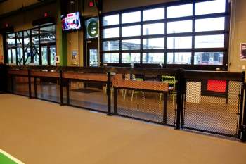 Indoor fencing separating pickleball courts from seating