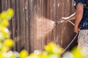 Home Maintenance - Hose Sprayer Spraying Wood Fence with Stain