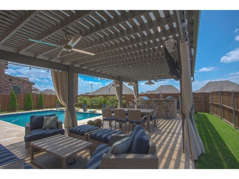 Outdoor Living - Outdoor living space with grey latticed patio cover, seating area, and outdoor kitchen