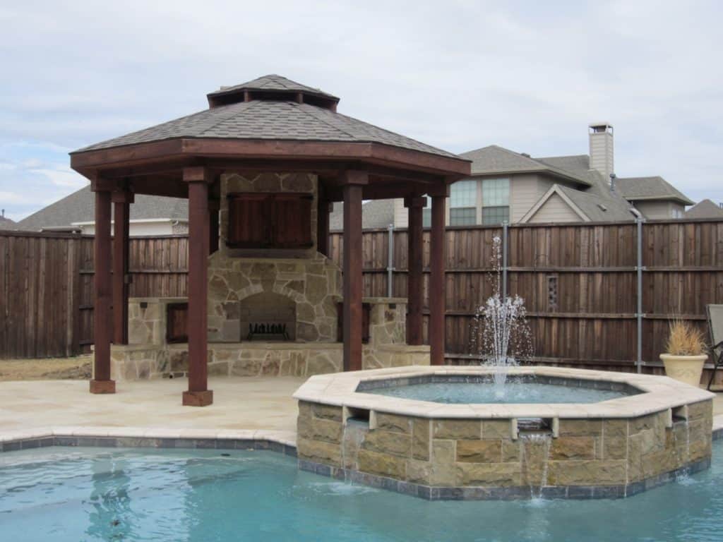 patio cover and pergola perks - pergola over outdoor fireplace and television by swimming pool