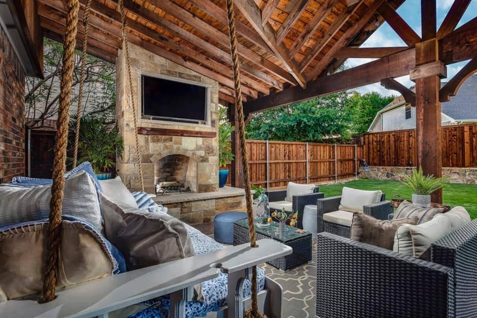 fall fire feature - outdoor fireplace under patio cover with seating and television