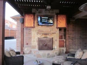 outdoor fire feature - fire place with television and outdoor seating